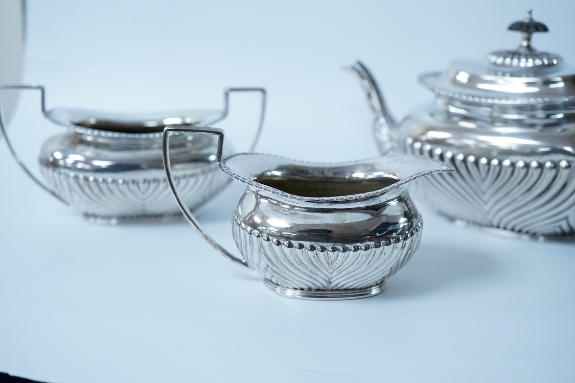 A late Victorian demi-fluted silver oval three piece bachelor's tea set, by James Deakin & Sons, Chester, 1893, gross weight 15.7oz.
